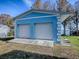 Detached two-car garage with light blue exterior and white roll-up doors at 908 N Lakeshore Blvd, Howey In The Hills, FL 34737