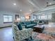 Open living area with teal sofa and patterned armchairs, overlooking the kitchen at 908 N Lakeshore Blvd, Howey In The Hills, FL 34737