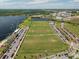 Aerial view showing a sprawling sports complex with well-maintained fields, ample parking, and scenic lakefront location at 10079 Gobat Aly, Orlando, FL 32827