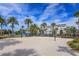 Sandy volleyball court in front of multi-story residential homes surrounded by manicured lawns and palm tree landscaping at 10079 Gobat Aly, Orlando, FL 32827