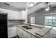 Modern kitchen with white cabinets, granite countertops, and black appliances at 1015 Stucki Ter, Winter Garden, FL 34787