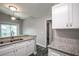 Modern kitchen with white cabinets, granite countertops, and black appliances at 1015 Stucki Ter, Winter Garden, FL 34787