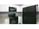 Modern kitchen with white cabinets, granite countertops and black appliances at 1015 Stucki Ter, Winter Garden, FL 34787