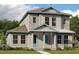 Two-story house with light gray siding, teal door, and a grassy lawn at 10221 Medawar St, Orlando, FL 32827