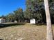 Large backyard with two sheds and mature trees at 11221 Lake Eustis Dr, Leesburg, FL 34788