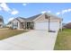 Beige house with a two-car garage and basketball hoop at 11272 Stewart Loop, Oxford, FL 34484