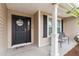 Front entrance with black door, welcome wreath, and seating at 11272 Stewart Loop, Oxford, FL 34484