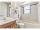 Bathroom showcasing a tub, white tile, window, and a vanity with wooden cabinets at 118 Shomate Dr, Longwood, FL 32750