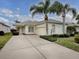 Single-story home with two palm trees and driveway at 12060 Se 176Th Loop, Summerfield, FL 34491