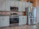 Stainless steel appliances and white shaker cabinets in kitchen at 12060 Se 176Th Loop, Summerfield, FL 34491