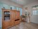 Sunroom features wood cabinet, comfy chair, and stained-glass window at 1218 Augustine Dr, The Villages, FL 32159