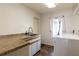 Bright laundry room with tile flooring, built-in cabinets, and a window at 12430 Blue Heron Way, Leesburg, FL 34788