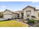 House exterior featuring a two-car garage and landscaped yard at 12592 Se 97Th Terrace Rd, Summerfield, FL 34491