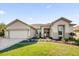 House exterior featuring a two-car garage and landscaped yard at 12592 Se 97Th Terrace Rd, Summerfield, FL 34491