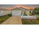 Inviting exterior featuring a white picket fence and a two-car garage at 1280 Mount Vernon Way, The Villages, FL 32162