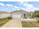 Tan house with white picket fence, double garage, and screened porch at 1280 Mount Vernon Way, The Villages, FL 32162