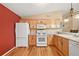 Spacious kitchen with light wood cabinets and a white refrigerator at 1280 Mount Vernon Way, The Villages, FL 32162