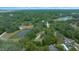 Aerial view showing home, pond, and surrounding landscape at 13588 Sw 105Th Pl, Dunnellon, FL 34432