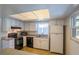 Galley-style kitchen with white cabinets and black appliances at 13635 Berkshire Ct, Grand Island, FL 32735