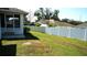 A well maintained, grassy backyard enclosed by a white fence at 137 Country Lakes Cir, Groveland, FL 34736