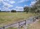 Open pasture with wooden fence and metal gate at 1392 Sw 103Rd Ave, Webster, FL 33597