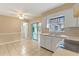 Kitchen with white cabinets, tile floor, and sliding glass door to patio at 1395 Morningside St, Mount Dora, FL 32757