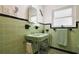 Retro bathroom with mint green tile, pedestal sink and shower at 1401 Lake Shore Blvd, Tavares, FL 32778