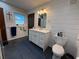 Modern bathroom with white vanity, shiplap walls, and dark tile floors at 1401 Lake Shore Blvd, Tavares, FL 32778