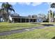 Ranch-style home exterior with a spacious lawn and mature trees at 1401 Lake Shore Blvd, Tavares, FL 32778