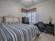 Bedroom with striped bedding, dresser, and workspace at 14267 Se 85Th Ter, Summerfield, FL 34491