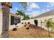 Spacious backyard with screened patio, gravel landscaping, and mature palm trees at 1521 Trenton Ln, The Villages, FL 32162