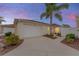 Exterior view of the house at dusk with garage and landscaping at 1521 Trenton Ln, The Villages, FL 32162