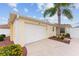 Attached garage with a white door and landscaping at 1521 Trenton Ln, The Villages, FL 32162