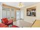 Bright sunroom with two red armchairs and a ceiling fan at 1526 Lozano Ave, Lady Lake, FL 32159