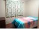 Bedroom with double bed and patterned curtains at 164 Jacaranda Dr, Leesburg, FL 34748