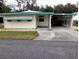 Front view of a single story home with carport at 164 Jacaranda Dr, Leesburg, FL 34748