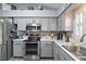 Bright kitchen with stainless steel appliances and gray cabinets at 1712 Palo Alto Ave, Lady Lake, FL 32159