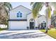 Two-story house with a gray exterior, white garage door, and landscaping at 17120 Cypresswood Way, Clermont, FL 34714