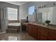 Elegant bathroom with a large soaking tub and granite vanity at 1735 Southern Oak Loop, Minneola, FL 34715