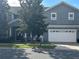 Two-story house with gray siding, white garage door, and landscaping at 1735 Southern Oak Loop, Minneola, FL 34715