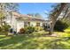 Landscaped backyard with large trees and lawn at 208 Desota Ct, The Villages, FL 32159