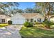 Cute yellow house with a 2-car garage and nicely landscaped lawn at 208 Desota Ct, The Villages, FL 32159