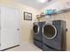 Laundry room with washer, dryer, and shelving at 208 Desota Ct, The Villages, FL 32159