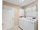 Laundry room with washer, dryer, and overhead cabinets at 2123 Barbosa Ct, The Villages, FL 32159