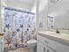 Clean bathroom with shower/tub combo, white vanity, and nautical-themed decor at 21509 Castle View Ct, Leesburg, FL 34748