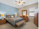 Spacious bedroom with light blue accent wall, queen bed, and wooden furniture at 21509 Castle View Ct, Leesburg, FL 34748