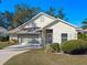 Tan house with screened-in garage and landscaping at 21509 Castle View Ct, Leesburg, FL 34748