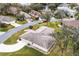 Aerial view of a well-manicured property showcasing lush landscaping and proximity to a serene lake at 21721 Loch Haven Pass, Leesburg, FL 34748