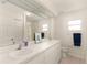 Well-lit bathroom with double sinks, vanity, and a shower behind a curtain at 21721 Loch Haven Pass, Leesburg, FL 34748