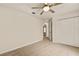Neutral bedroom features a ceiling fan, closet, and a glimpse into other rooms at 21721 Loch Haven Pass, Leesburg, FL 34748